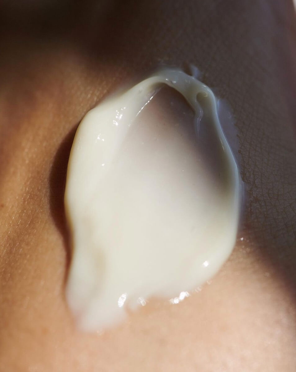 Close-up of a dollop of white cream on brown skin.