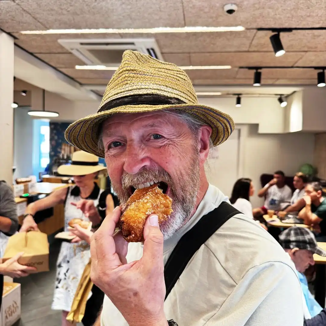 older epicurean traveler eating pastry
