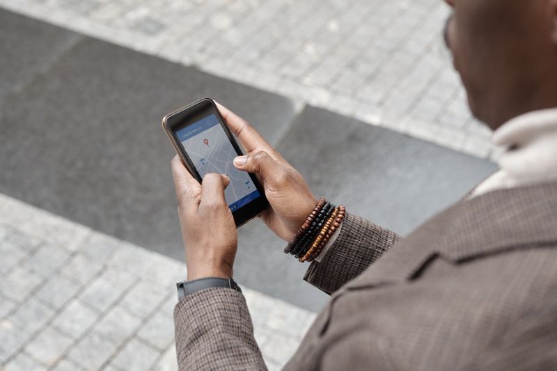 Person on a street using a map app to find a local business