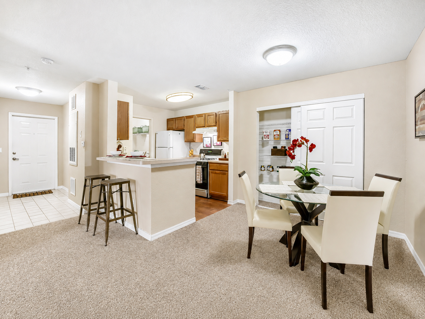 Wide view of dining area and kitchen with table