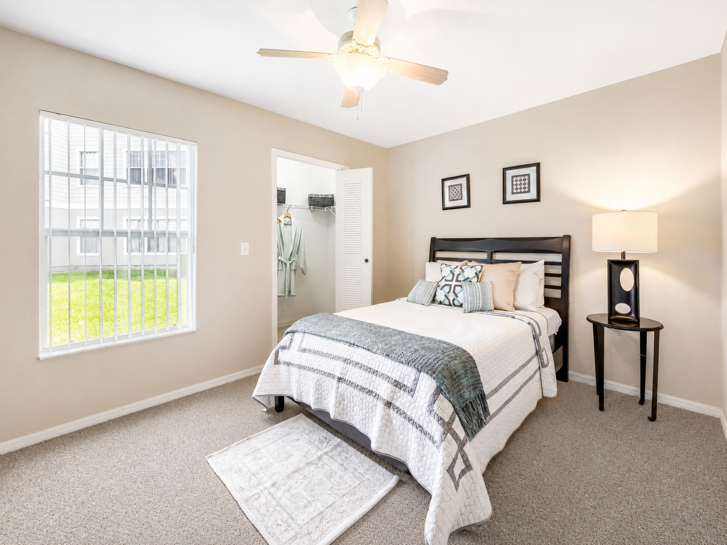 Bedroom with bed, ceiling fan, and large window