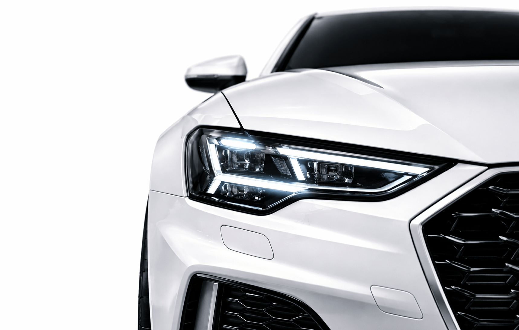 Close-up of a white car's front left side showing LED headlight and part of the black grille.