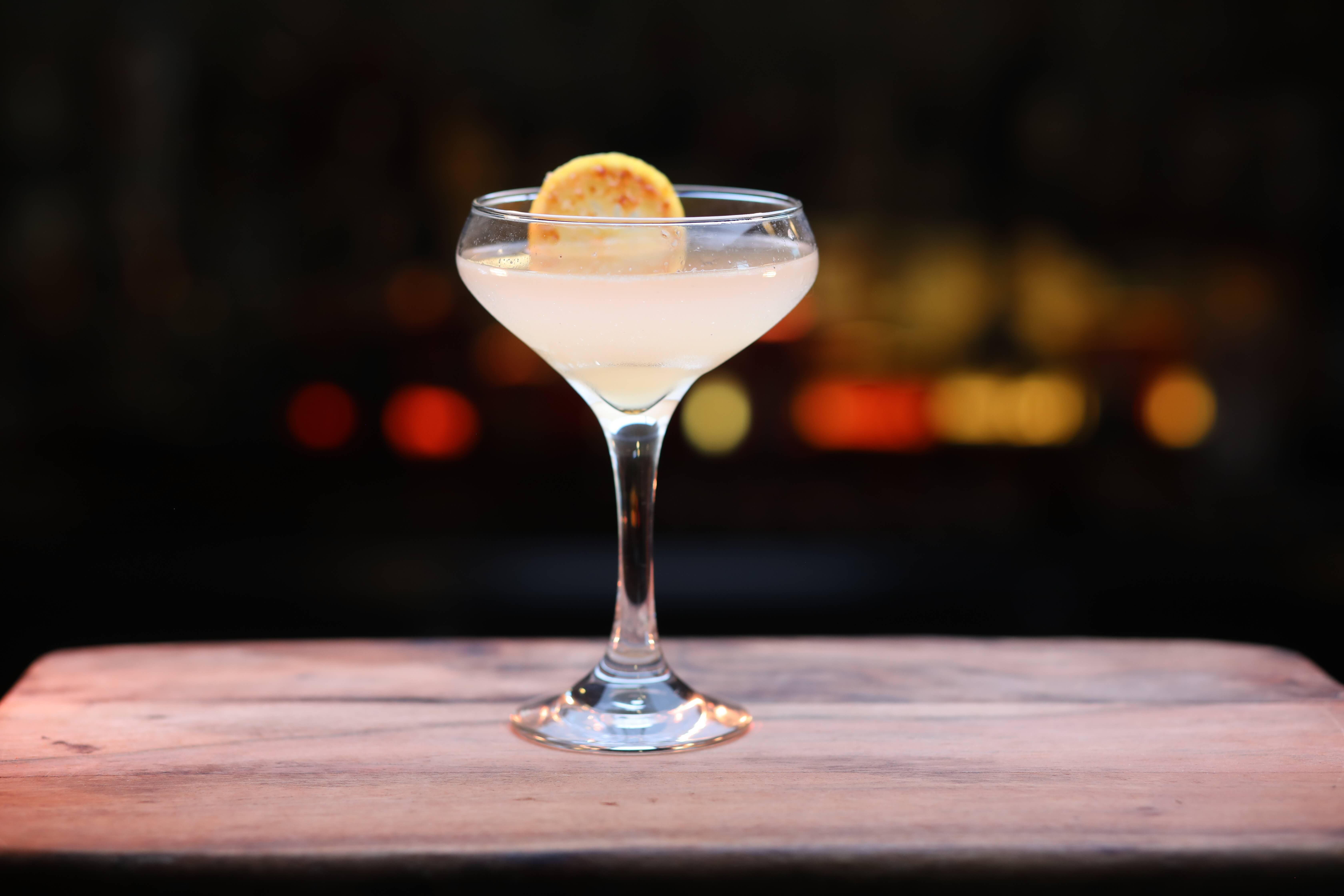 A fancy cocktail with a lemon wedge