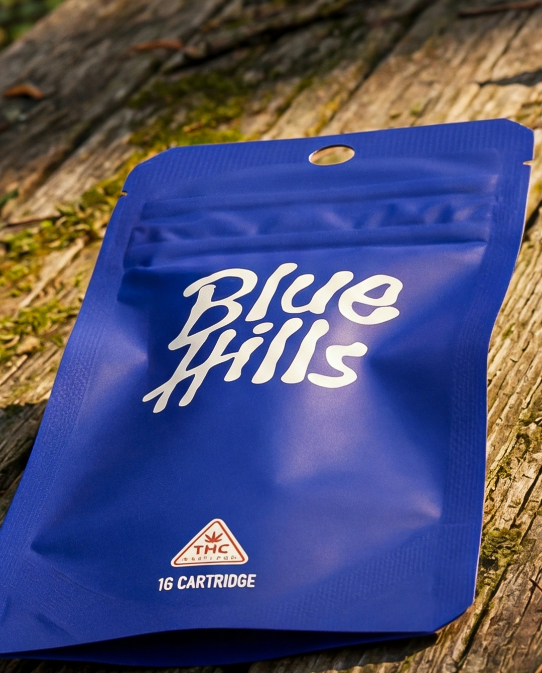 Blue resealable pouch labeled Blue Hills with a THC warning and 1G cartridge indication on a wooden surface.