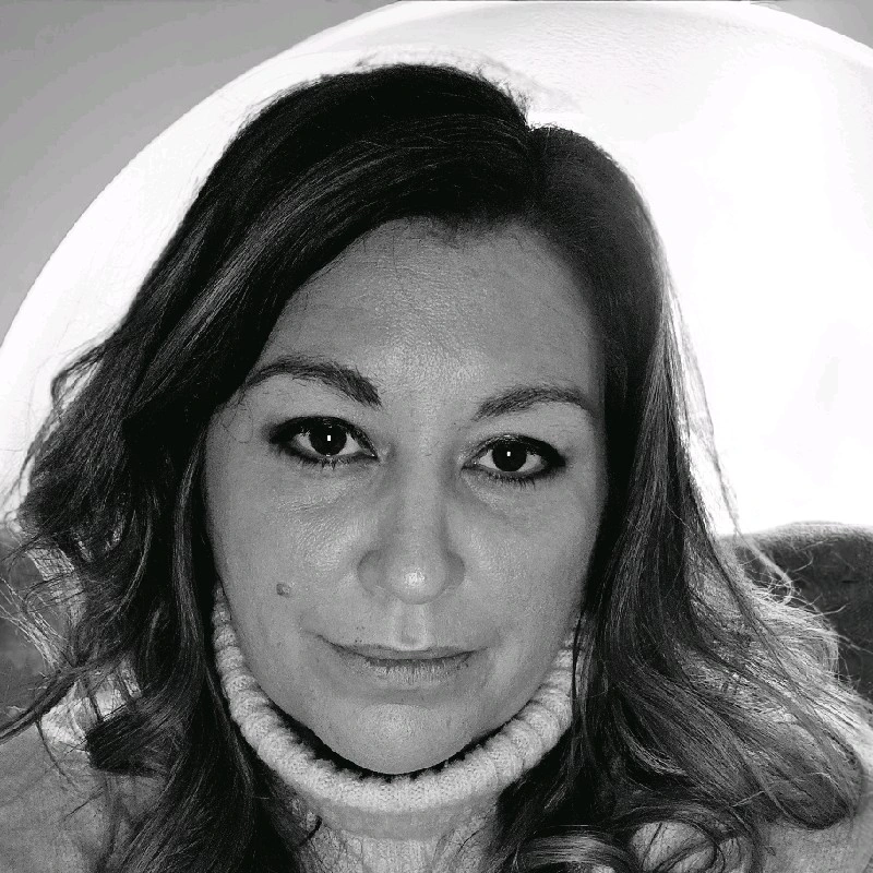 Black and white portrait of a woman with light wavy hair wearing a knitted turtleneck sweater.