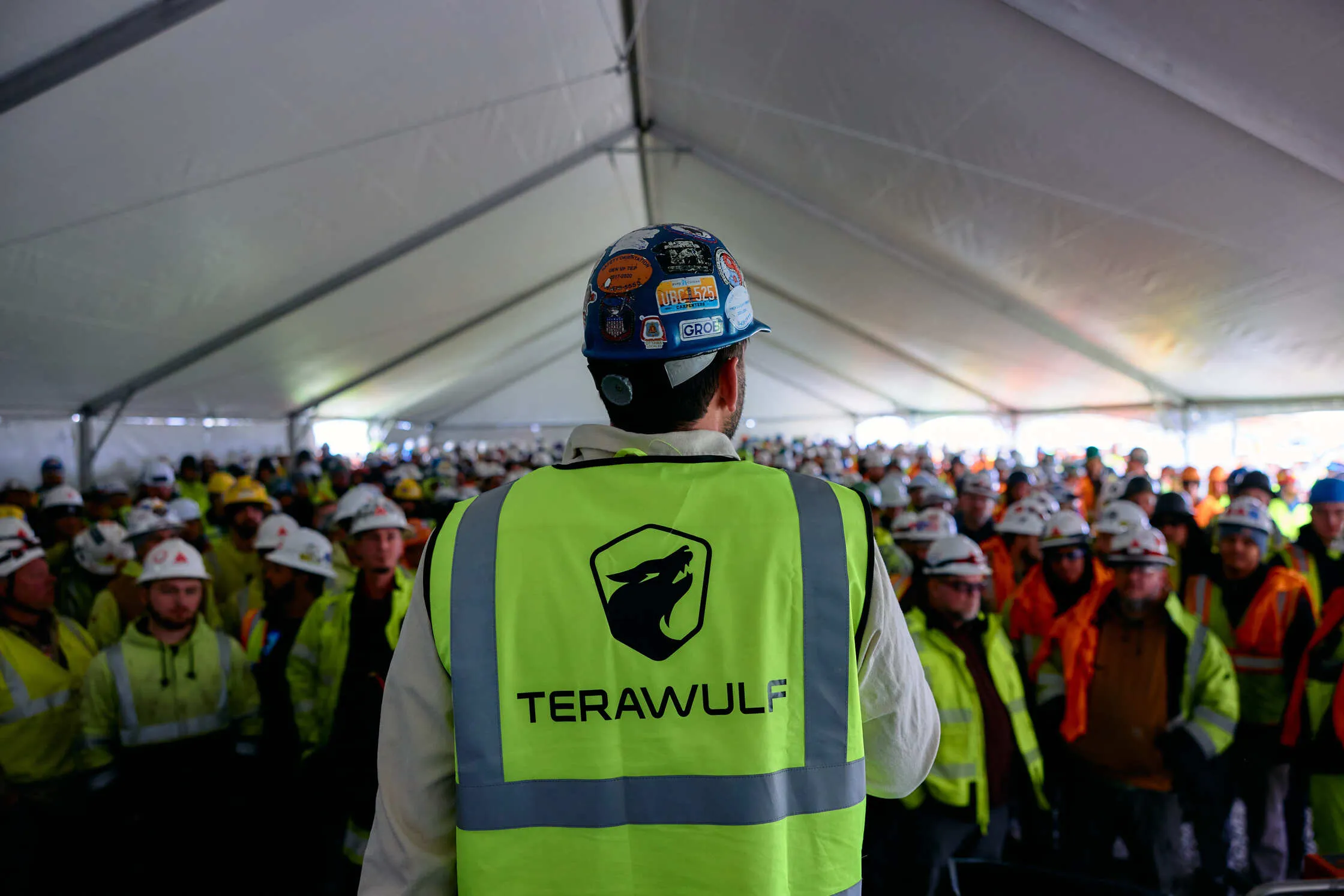 TeraWulf leader in branded vest addressing hundreds of local workers under a tent at Lake Mariner.
