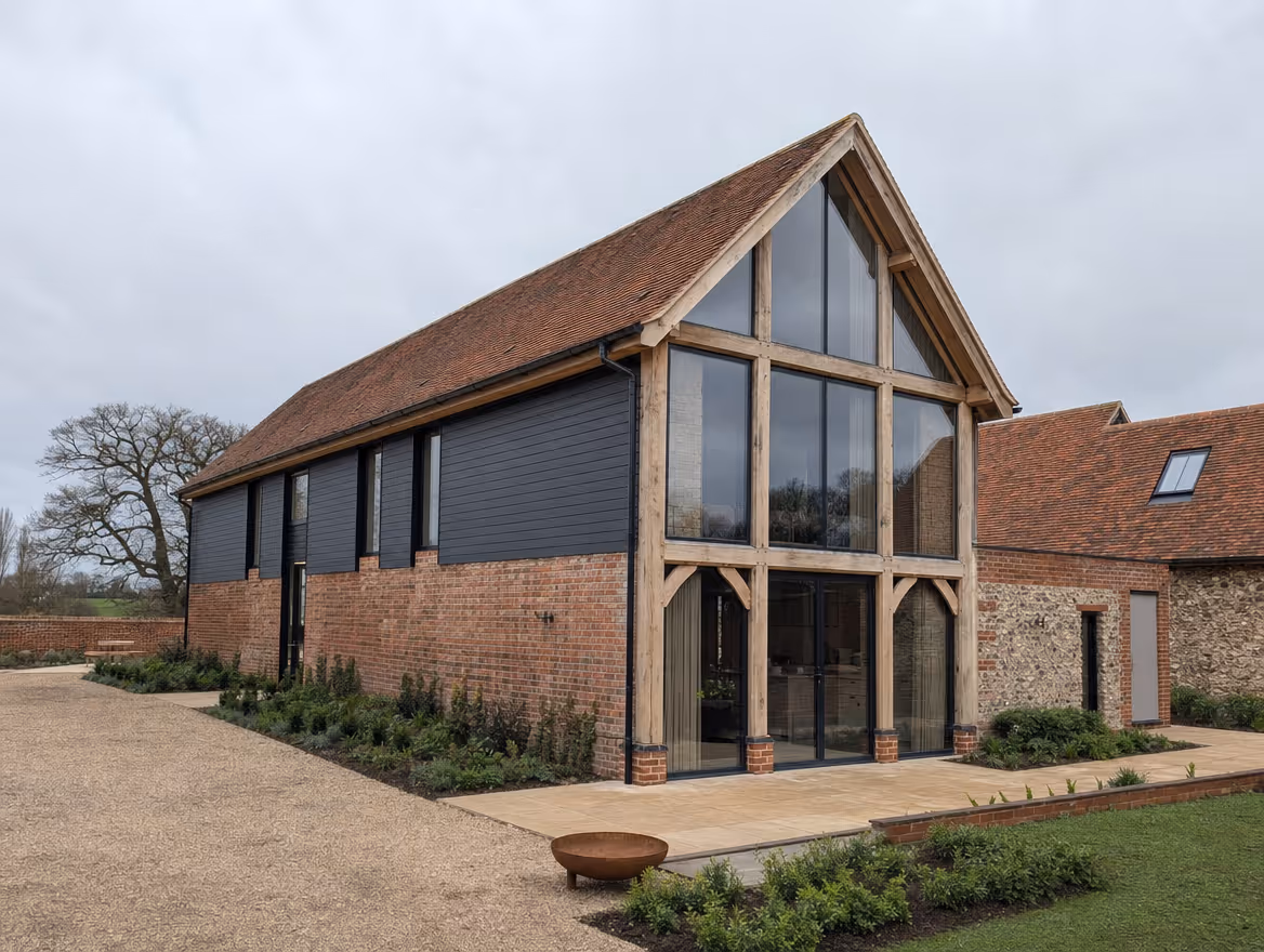 Completed barn conversion with exposed timber frame and large modern glazing