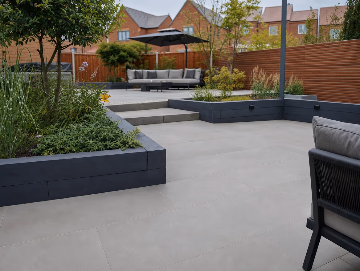 Finished porcelain patio with raised sleeper beds and seating area