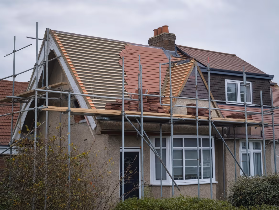 House roof being re-tiled with scaffolding and new tiles