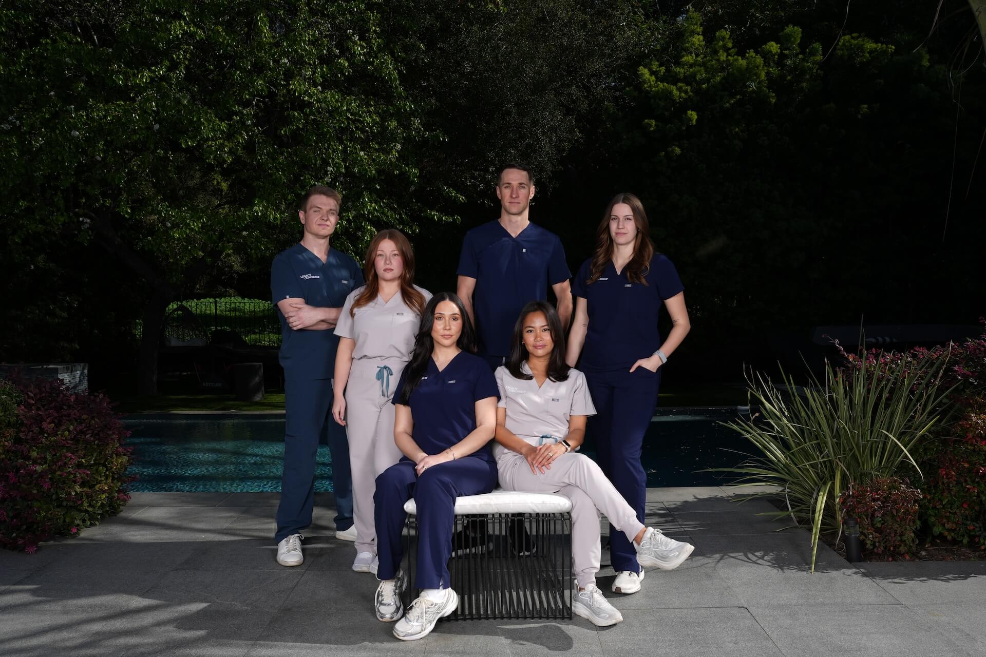 The Legacy Concierge team posing for a photo in a garden area.