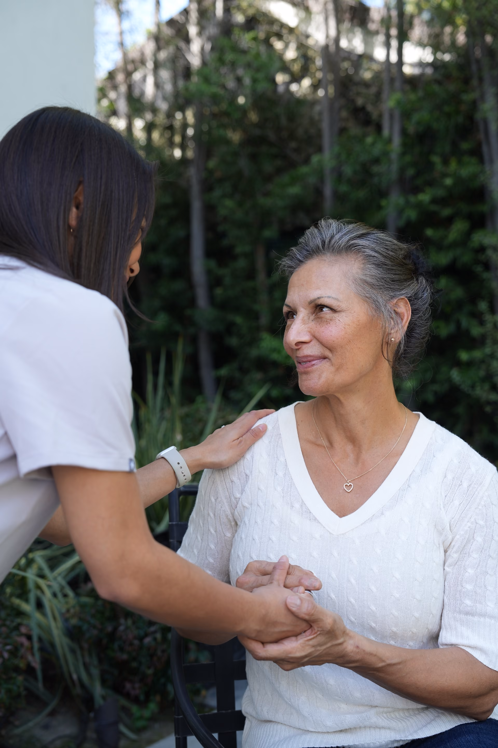 Nurse and woman greeting eachother.