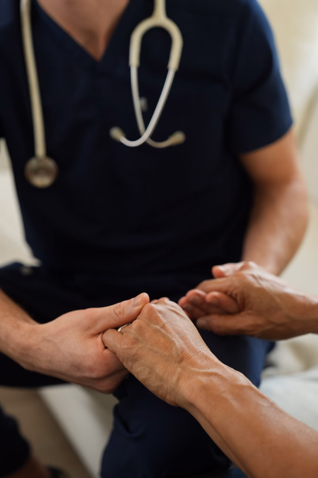 Nurse holding the hands of a patient.