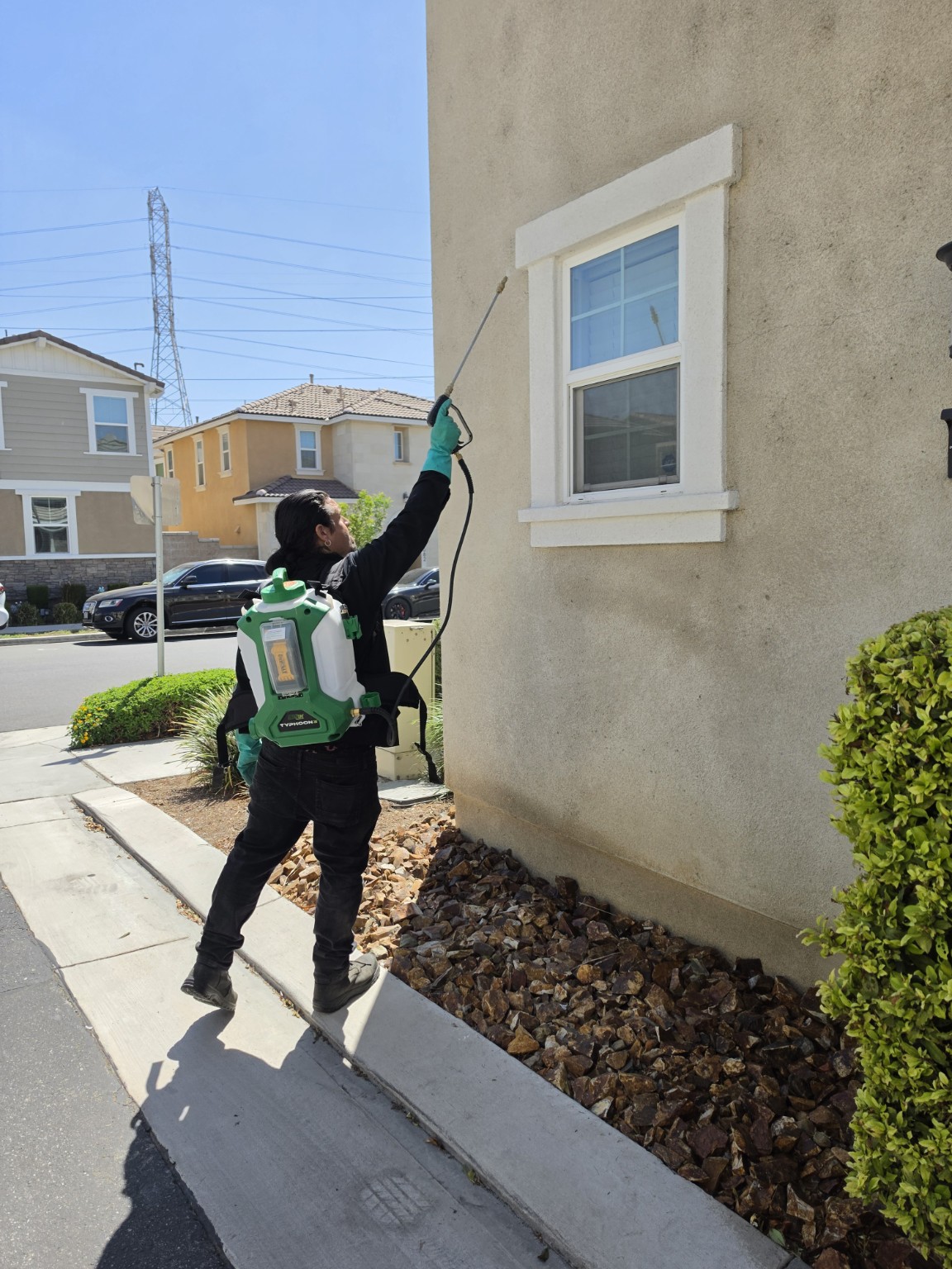 Pro Kill technician applying an exterior pest-control treatment in Riverside