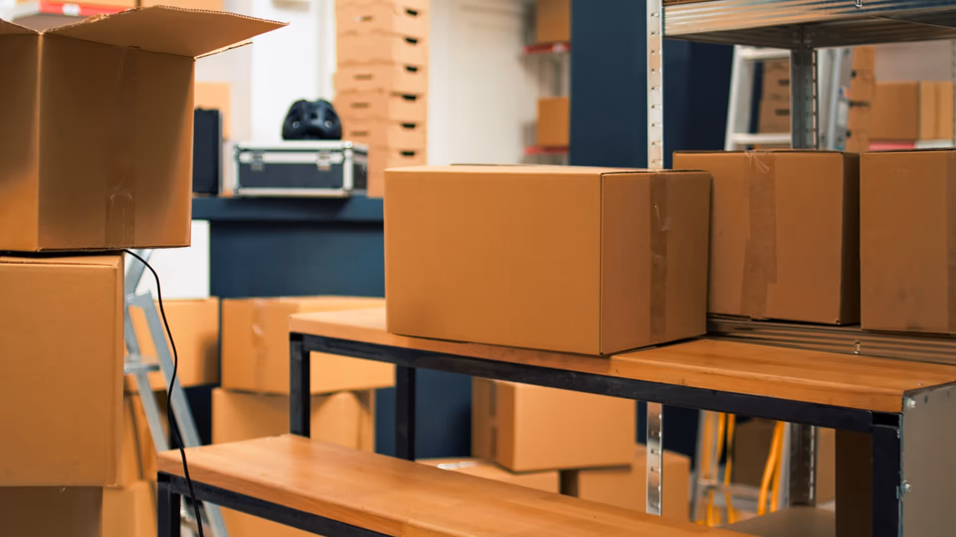 Warehouse shelves and floor filled with stacked brown cardboard boxes ready for shipment.