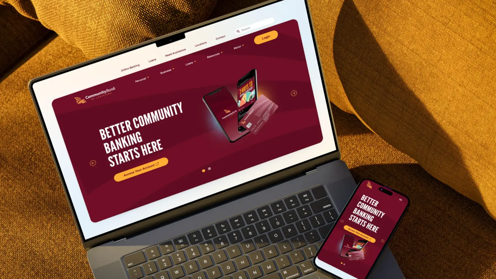 A laptop and phone on gold fabric showing a bank website headlined Better Community Banking Starts Here