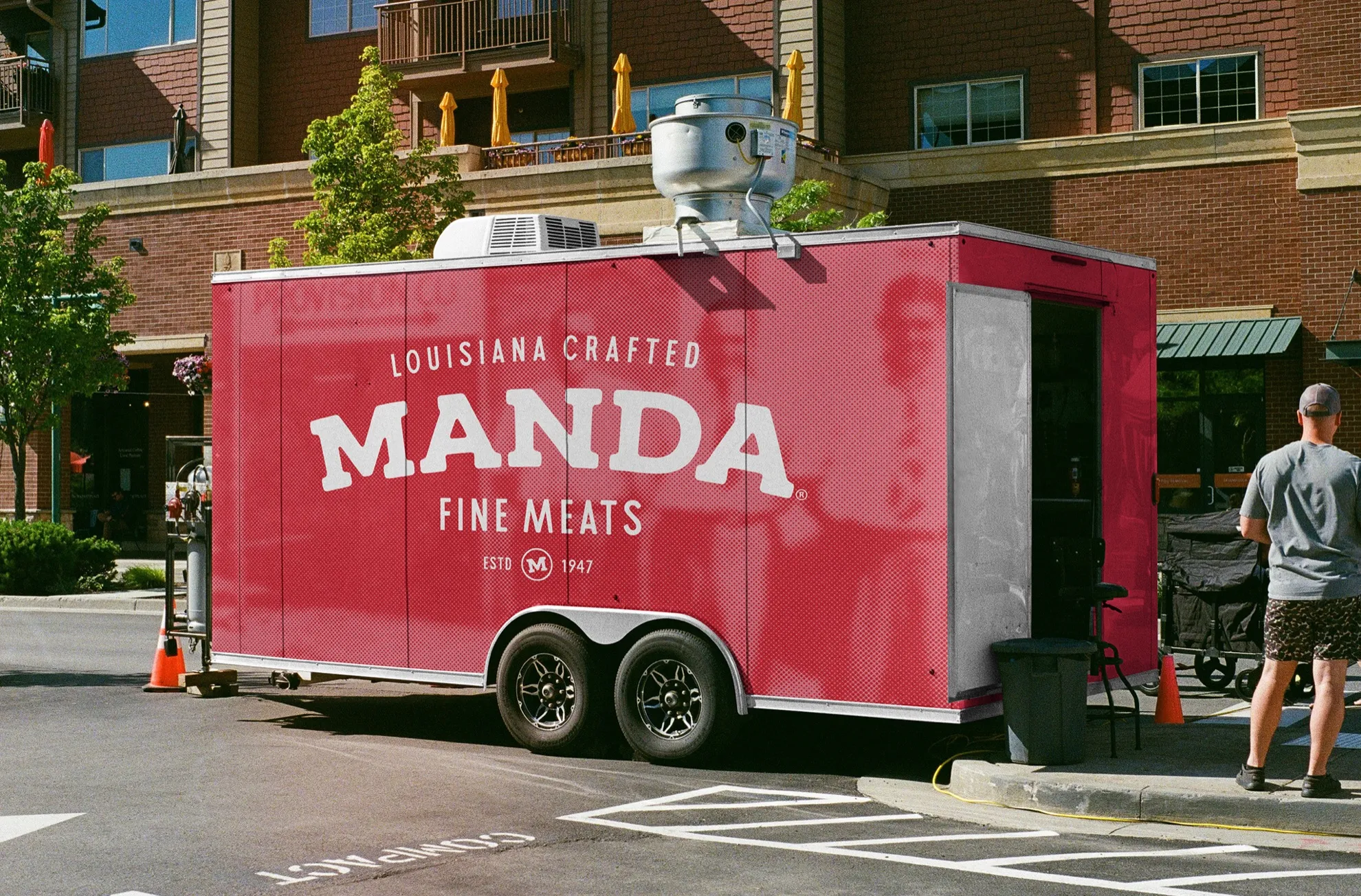A red Manda Fine Meats trailer wrap parked on a street