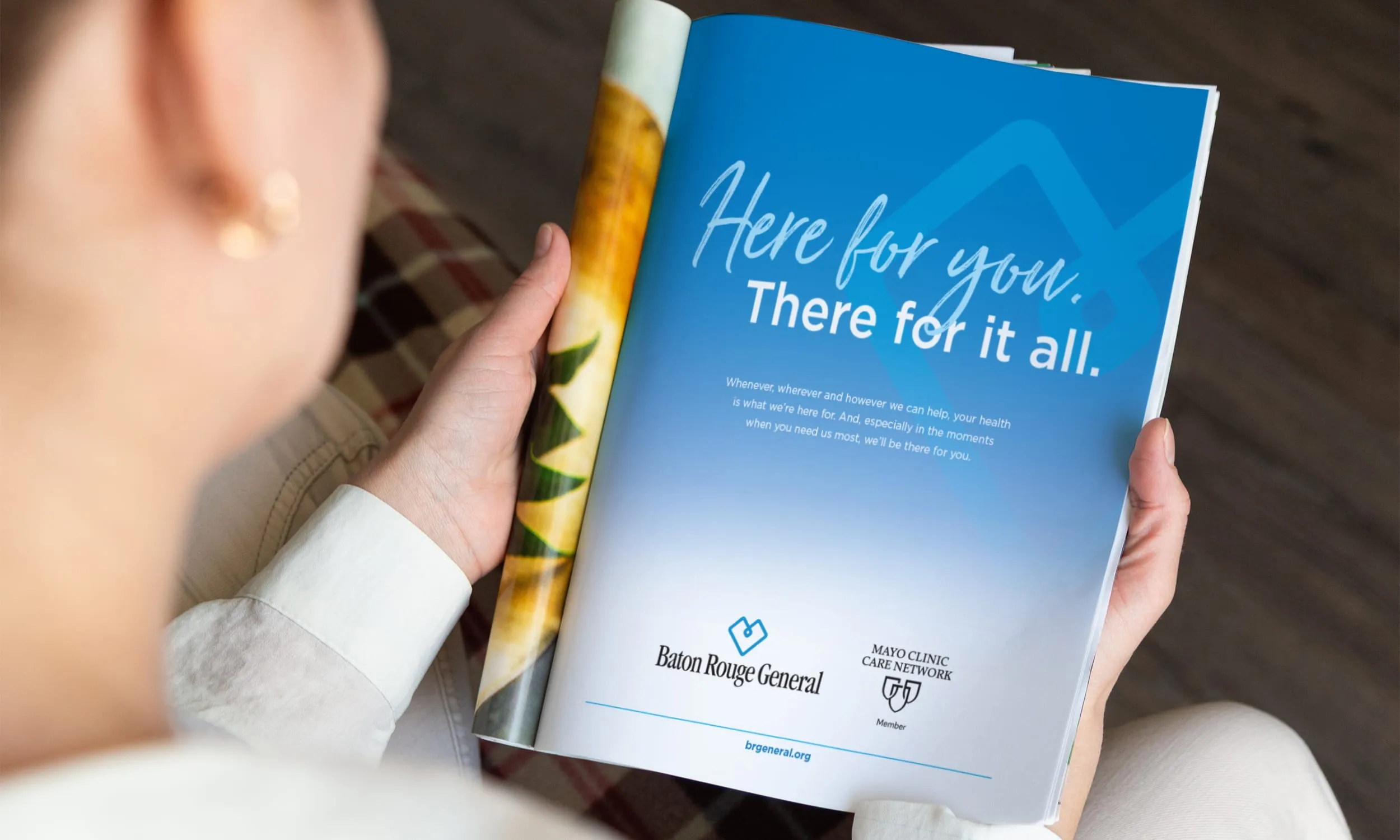 A person reading a Baton Rouge General magazine ad reading Here for You. There for It All.