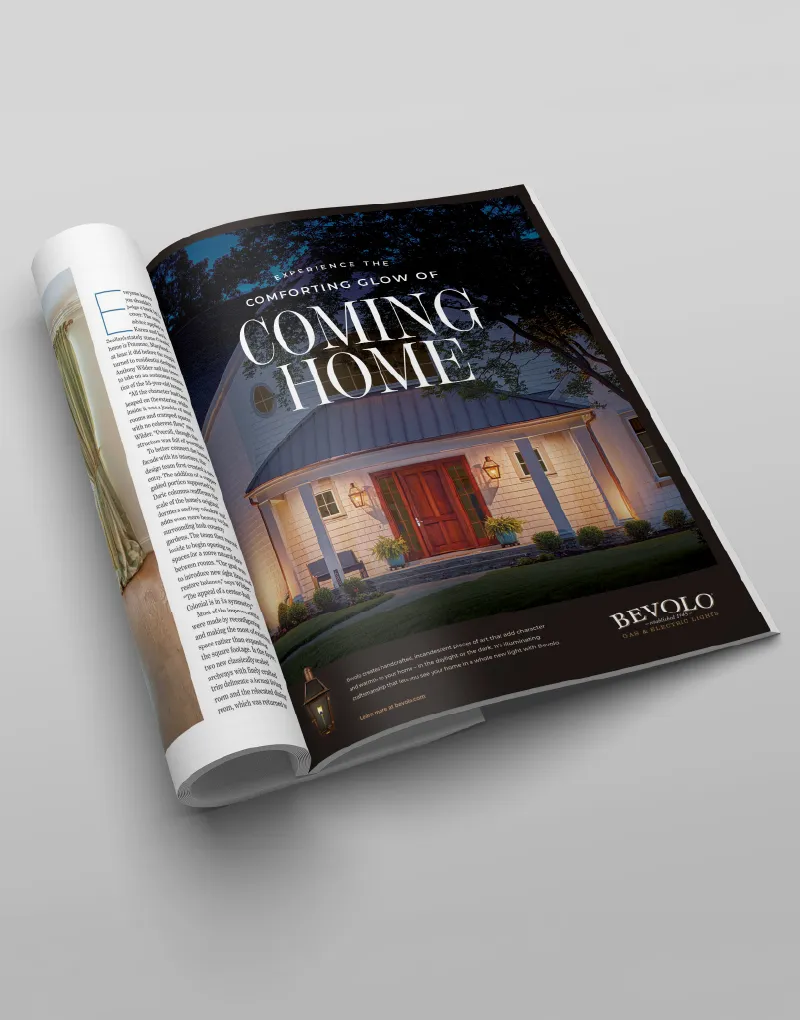 A rolled magazine showing a Bevolo ad headlined Coming Home