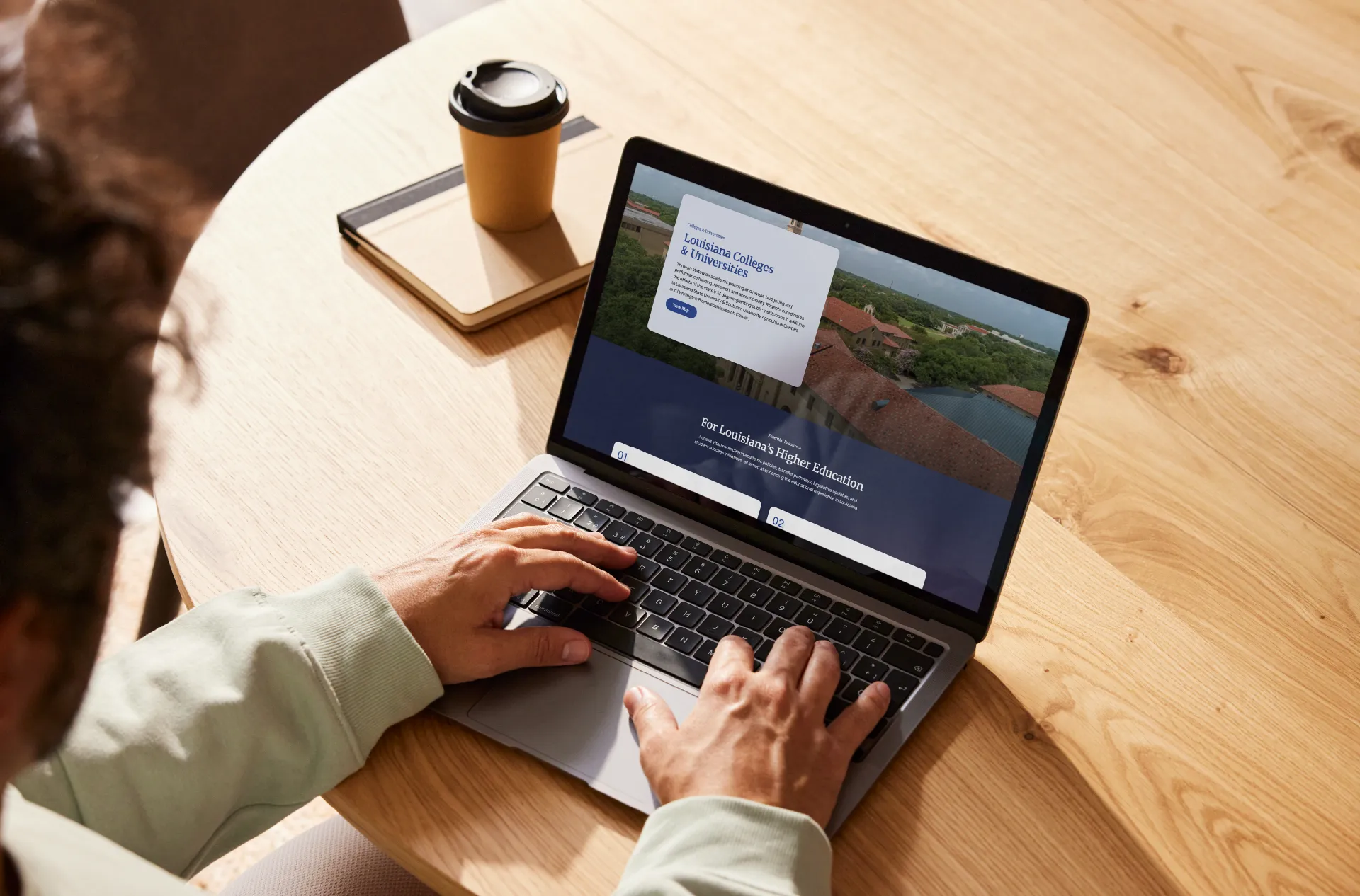 A person working at a laptop showing the Louisiana Board of Regents website