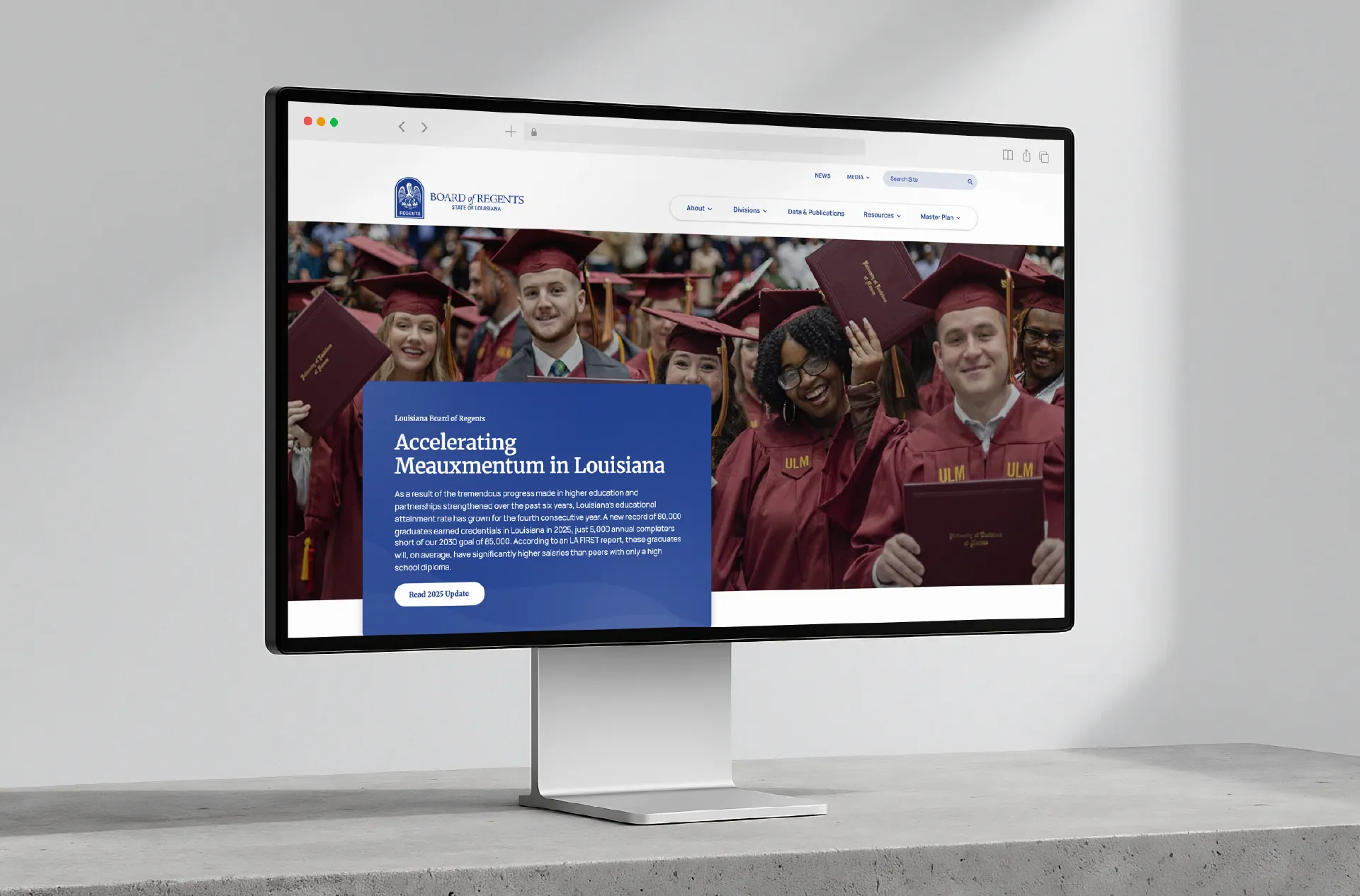 A desktop monitor showing the Louisiana Board of Regents website headlined Accelerating Measurement in Louisiana
