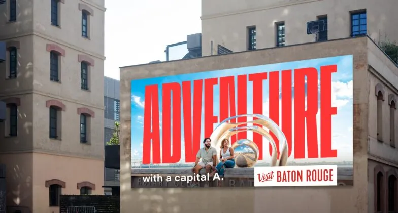 A Visit Baton Rouge billboard reading Adventure with a capital A on a city building