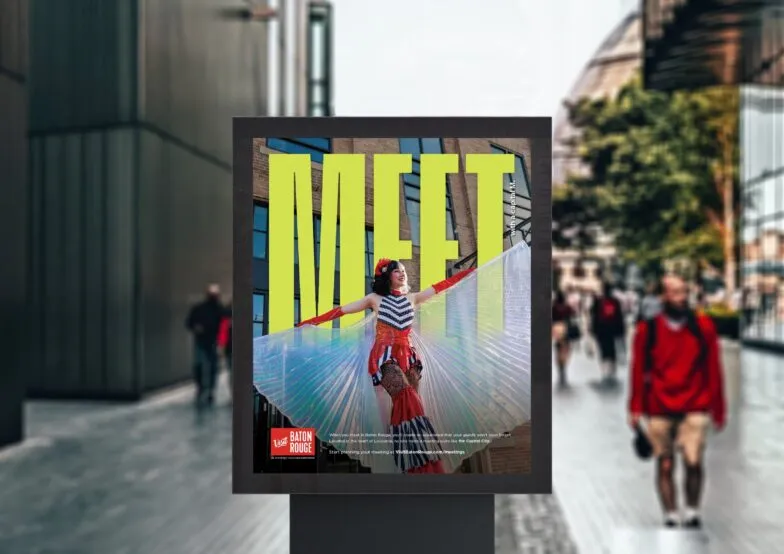 A Visit Baton Rouge poster reading Meet displayed on a street kiosk