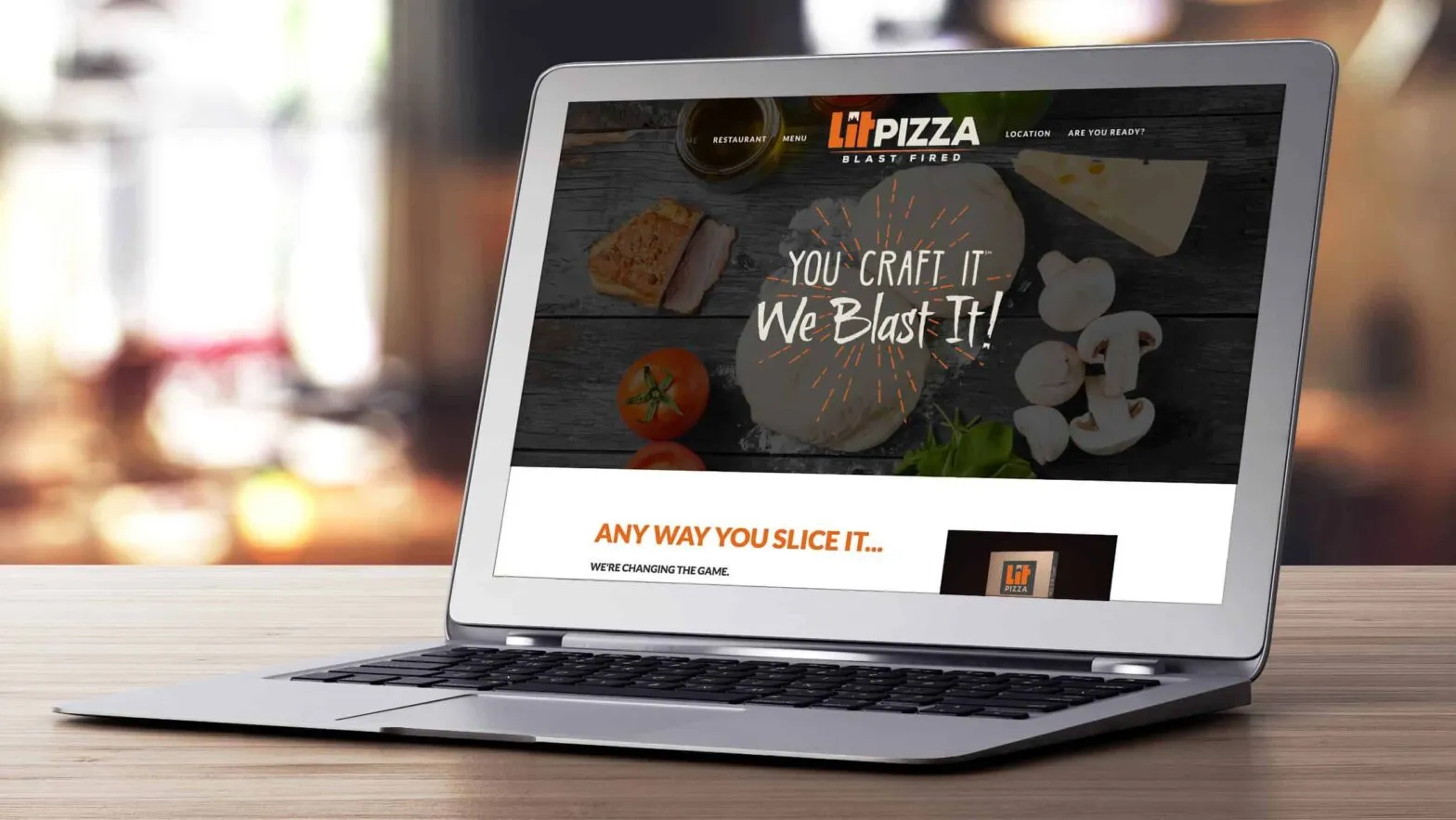 A laptop showing the LIT Pizza website reading You Craft It. We Blast It.