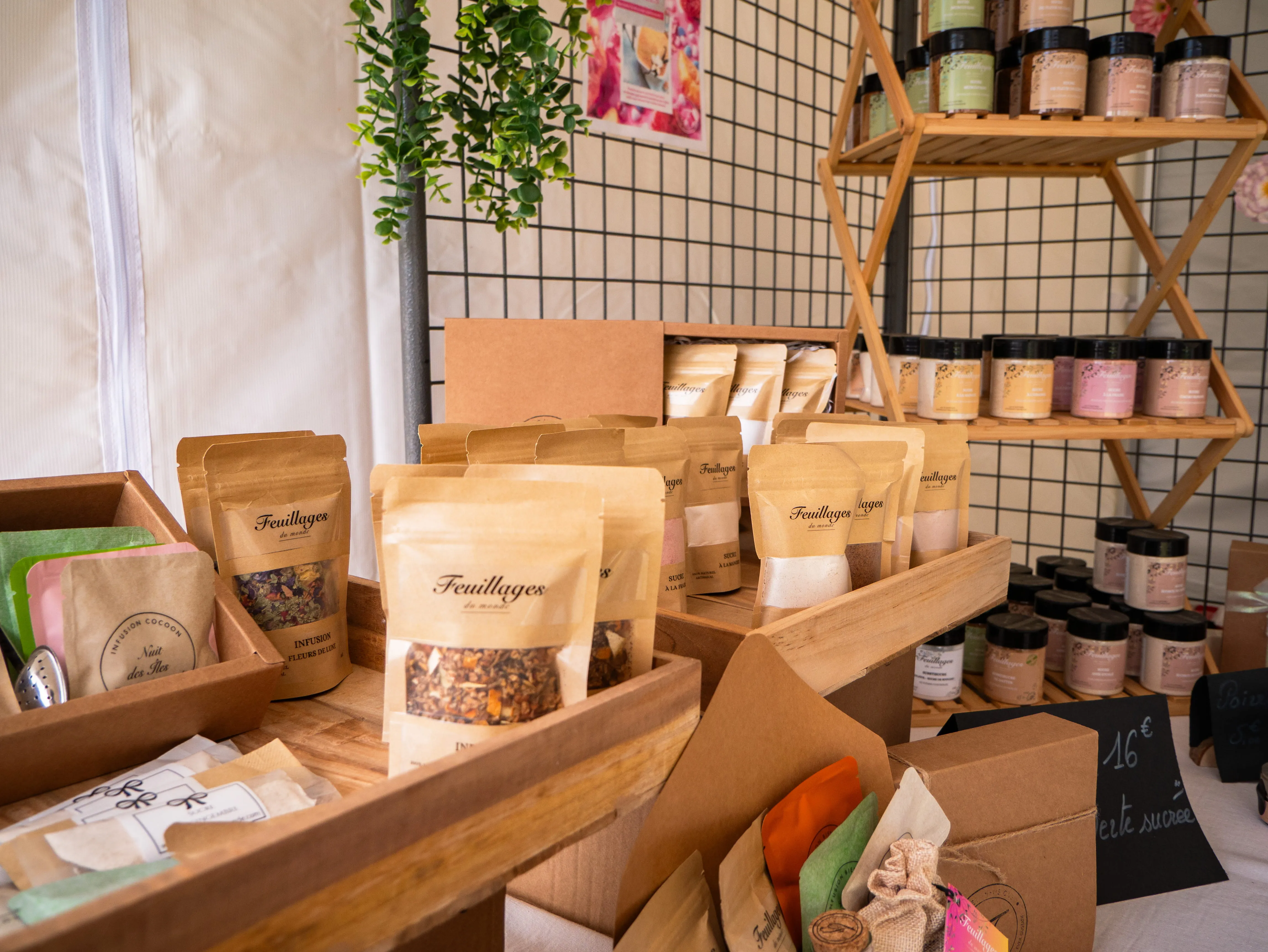 Étalage de sachets et bocaux de produits Feuillages du monde, incluant infusions et sucres aromatisés.