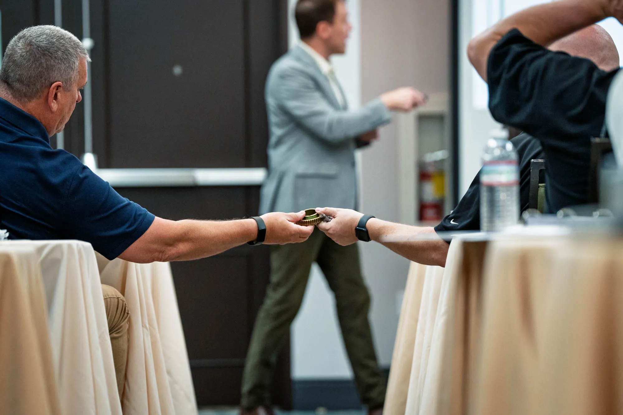 Attendees passing a gear sample during a Helios Gear School classroom session