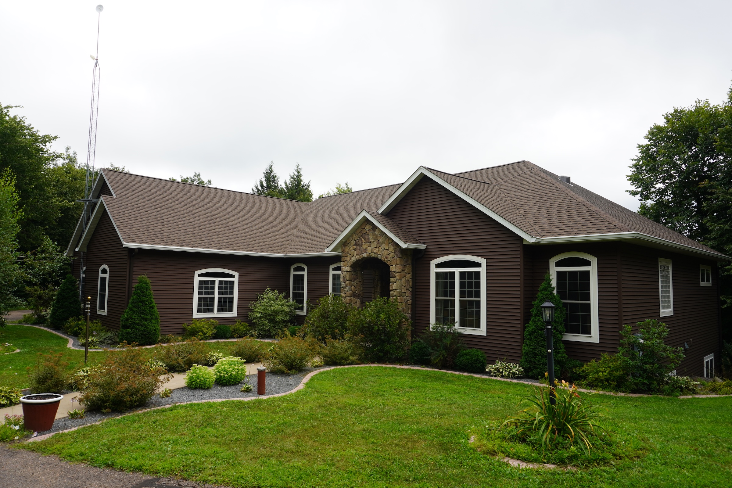 Front view of the completed roof replacement on the brown home, featuring new GAF Barkwood shingles and a clean, finished appearance.