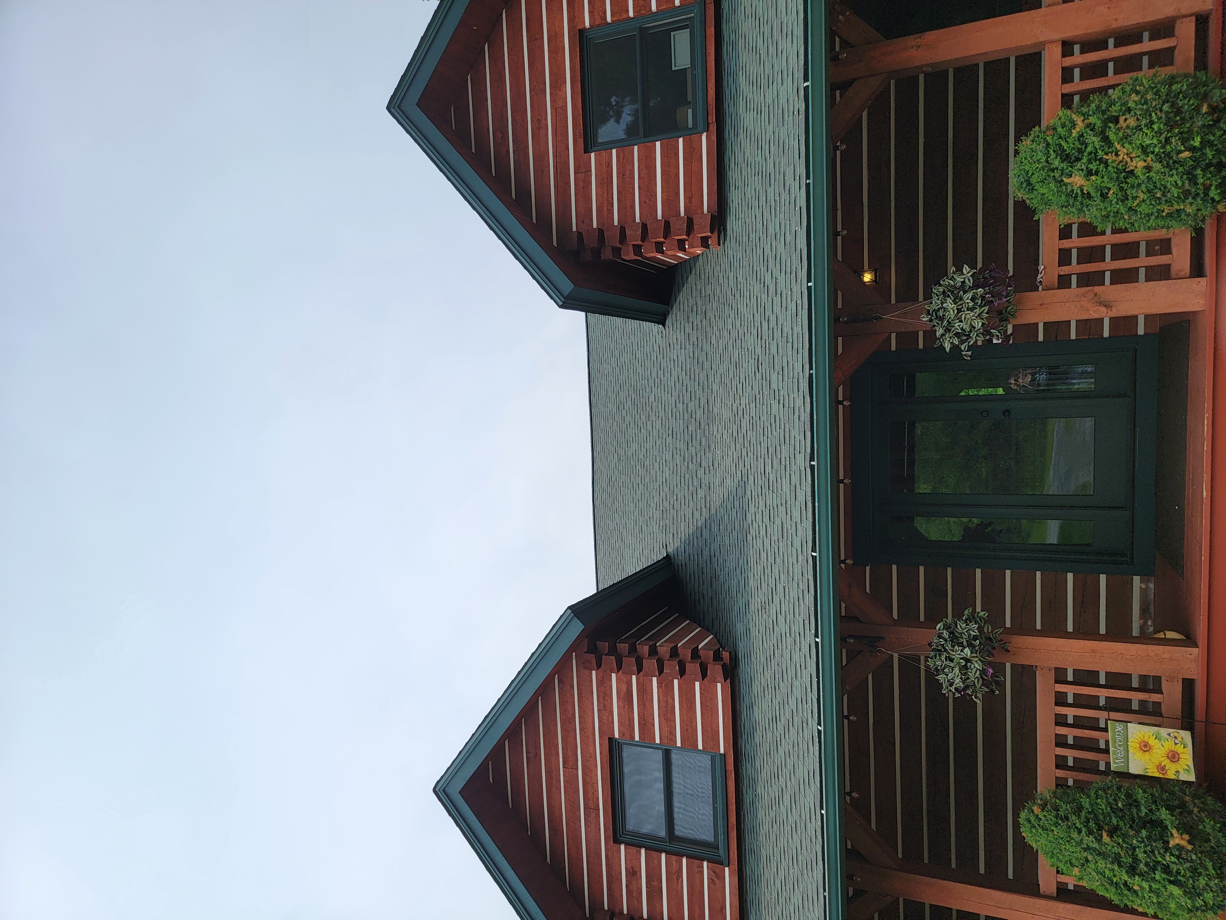 GAF Hunter Green roof replacement on a log-style home in Mosinee, WI with front dormers and covered porch.