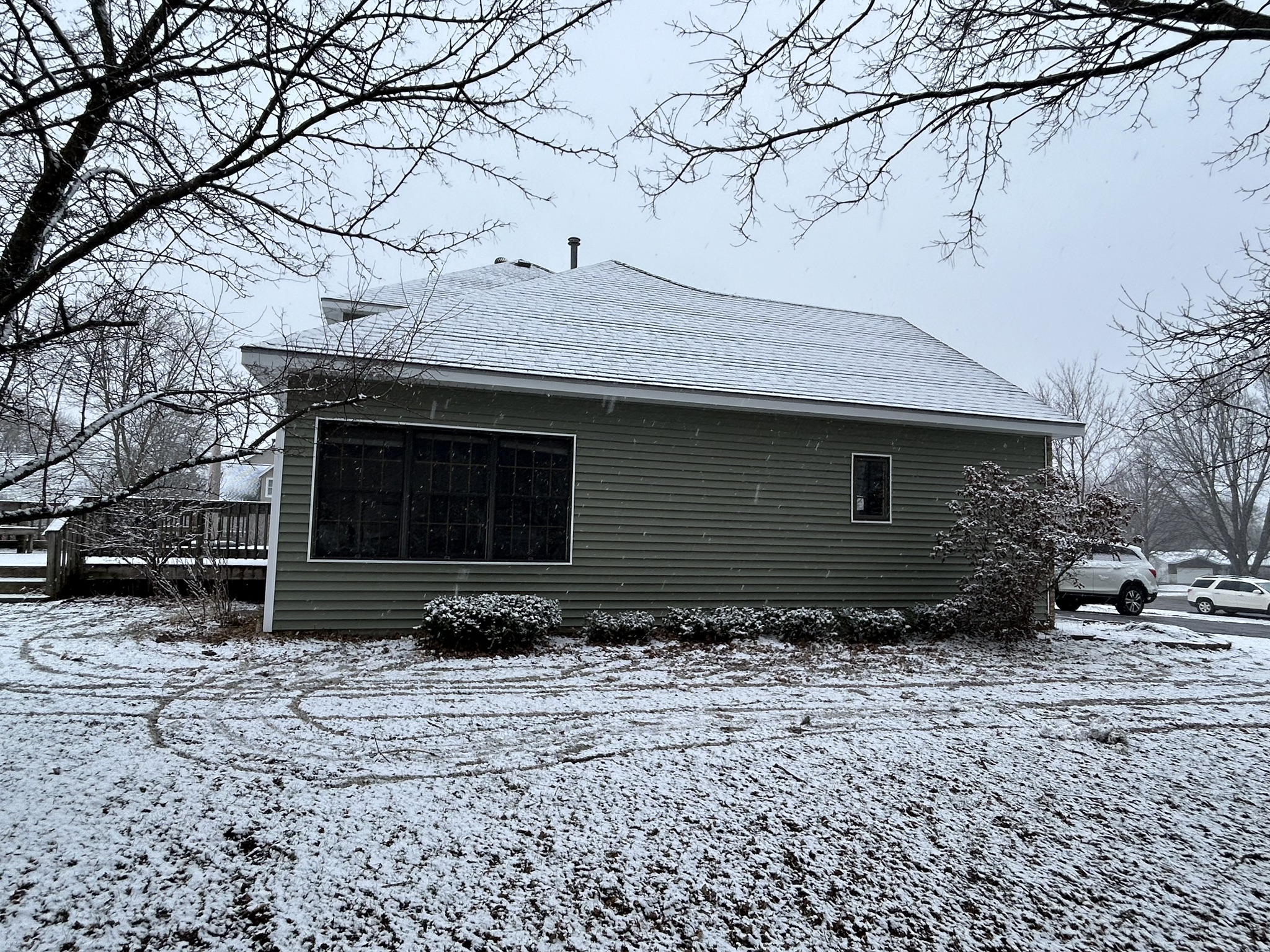 Side elevation of a Schofield, WI home showing Norandex Olive siding and large picture window in winter.