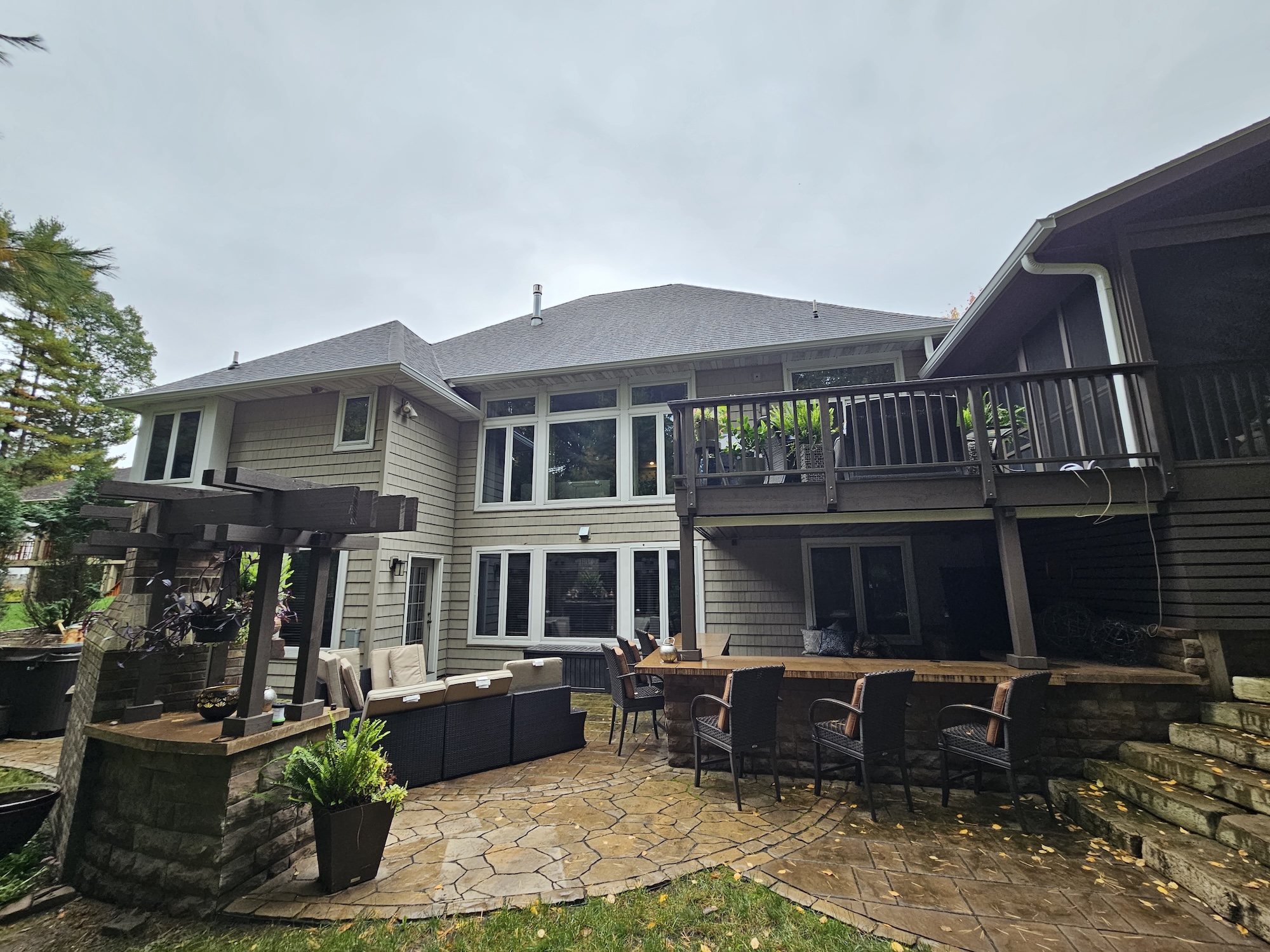 Rear patio view of a Wisconsin home with a new brown architectural shingle roof and outdoor living space.