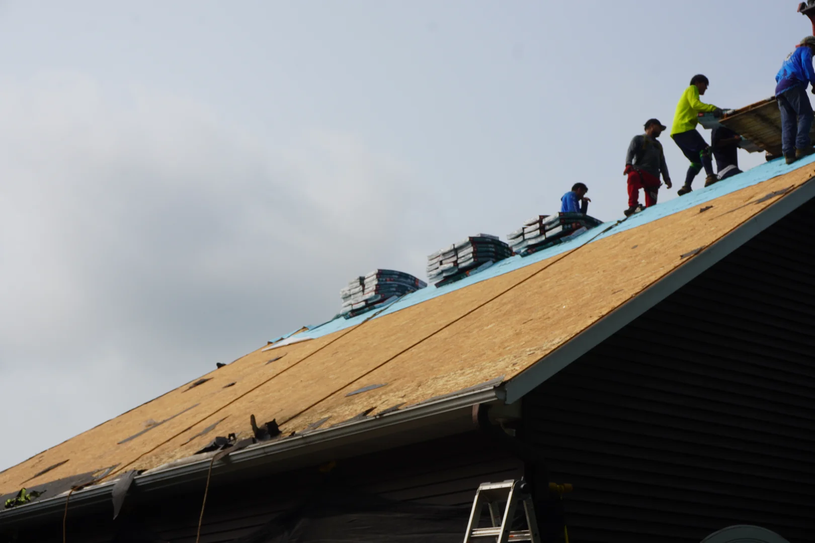 Professional roofing crew installing shingles safely on a home in Central Wisconsin