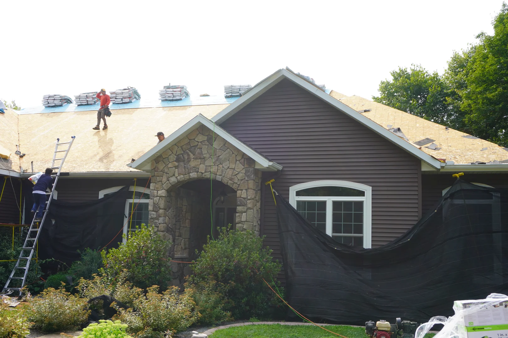 Central Wisconsin home inspector checking roof flashing and shingles near chimney Central Wisconsin home inspector checking roof flashing and shingles near chimney