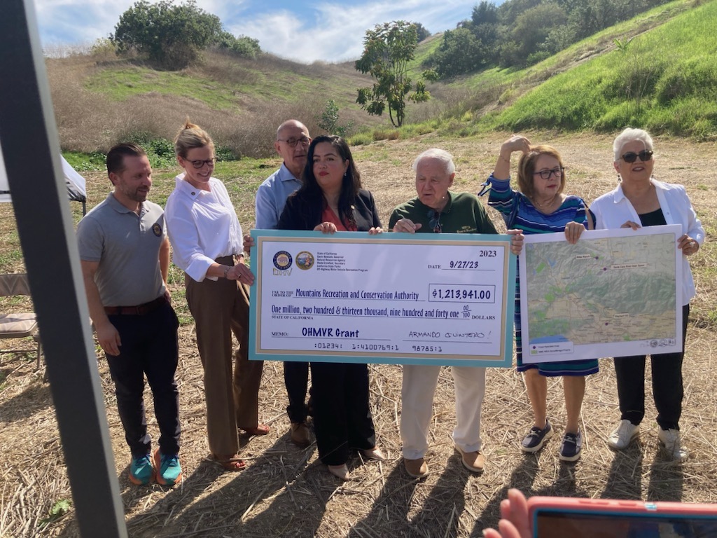 Receiving state funding. State legislators posing with community members.