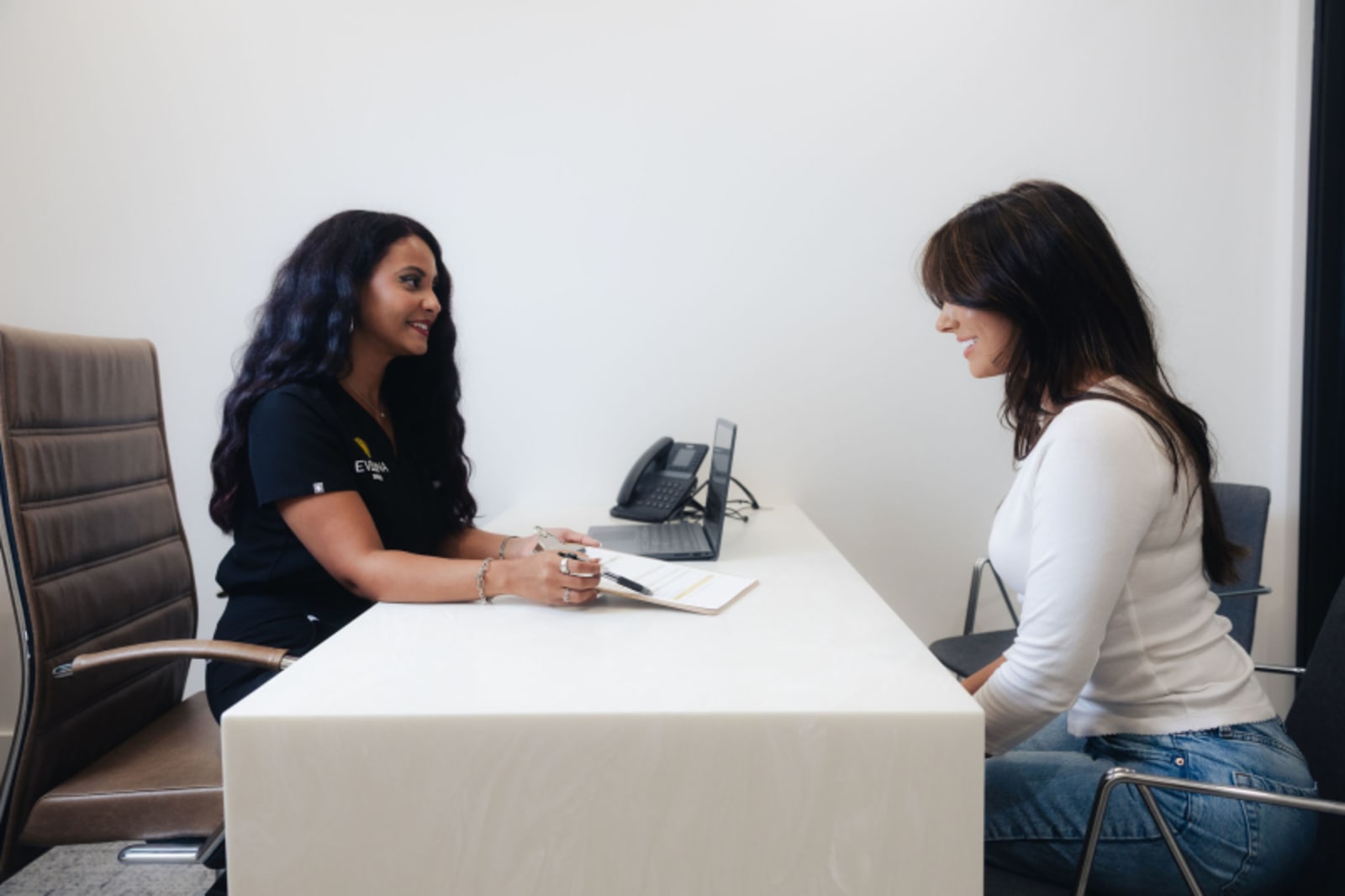 Female staff member showing patient information at Evelina Smiles consultation desk