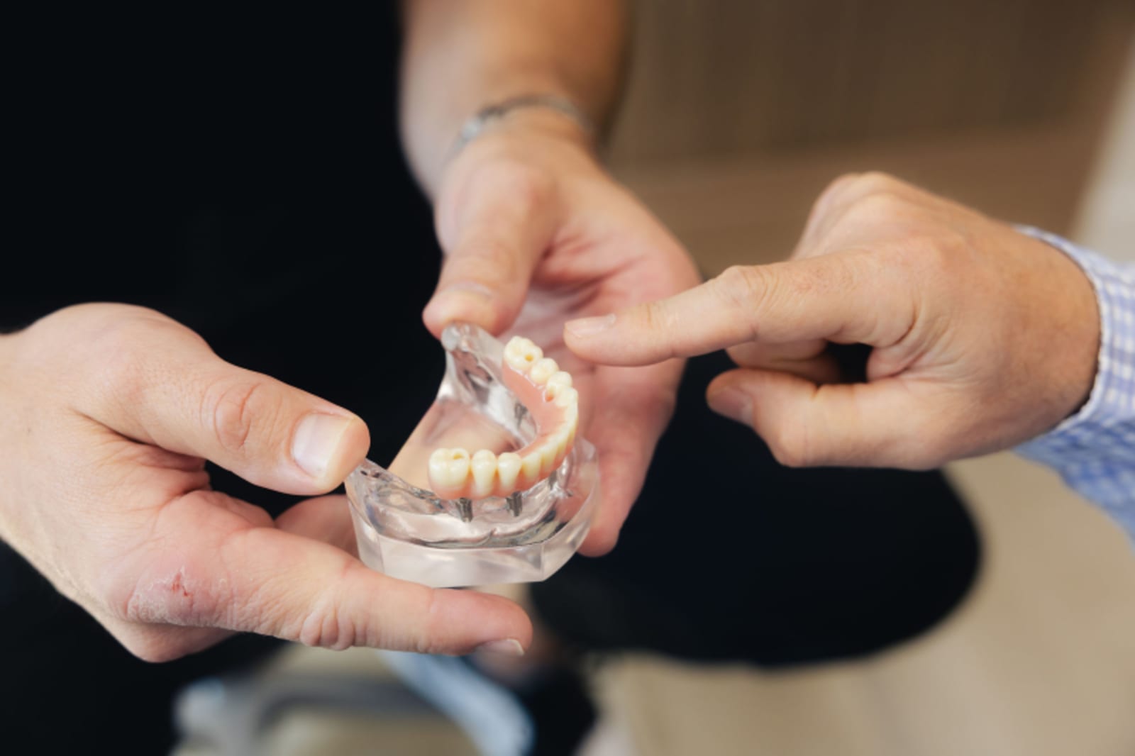 Close-up of hands examining a clear aligner tray during orthodontic treatment