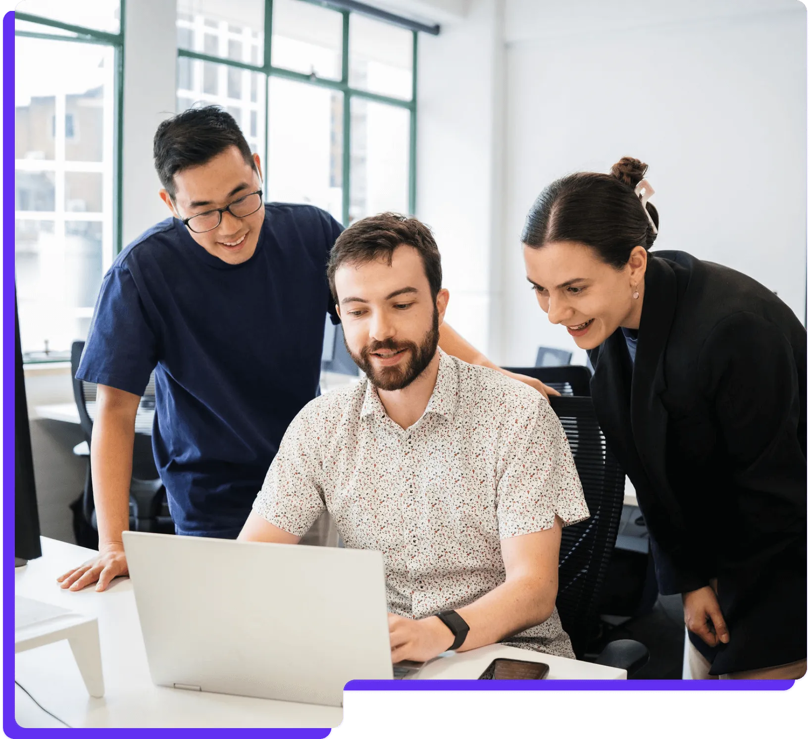 Three people looking at laptop
