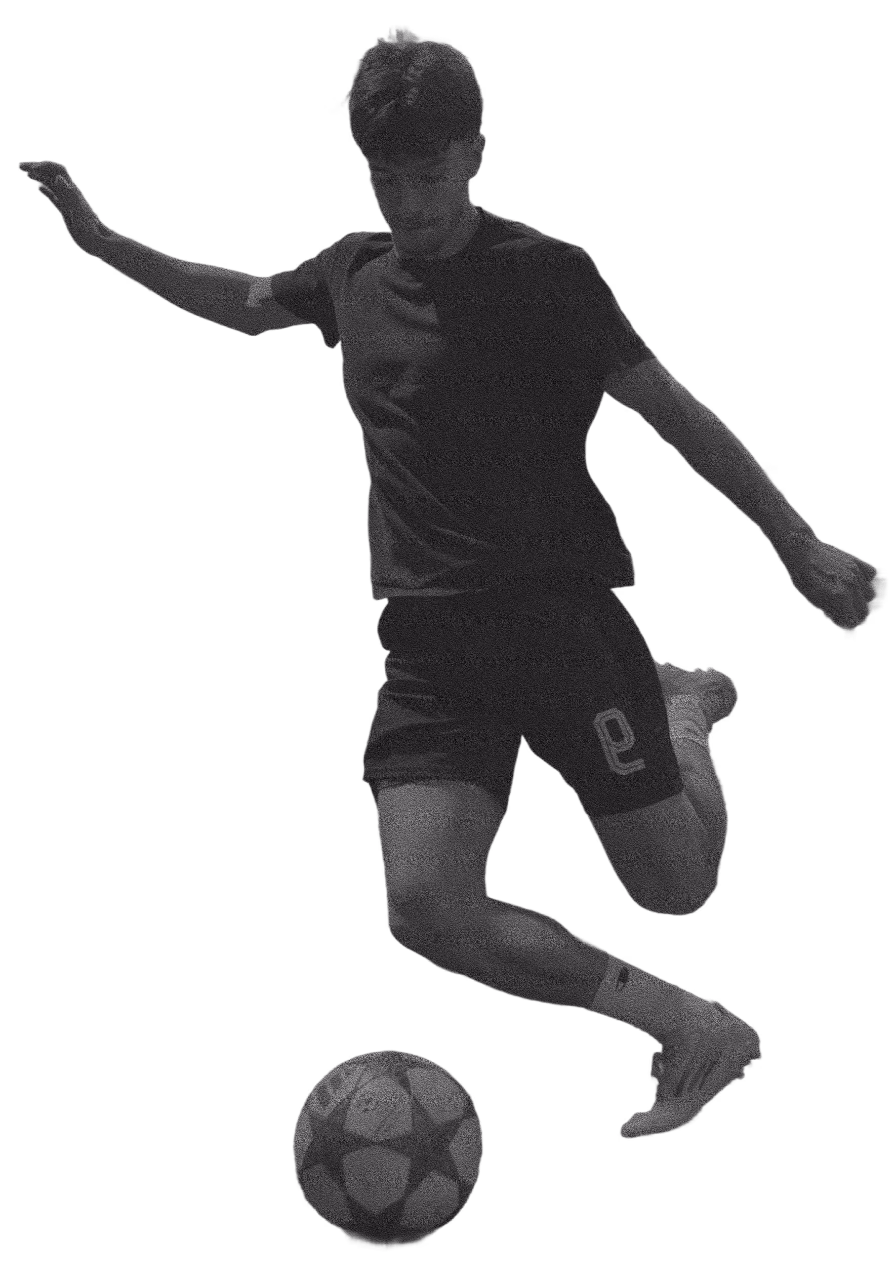 Soccer player in mid-air kicking a soccer ball with right foot.