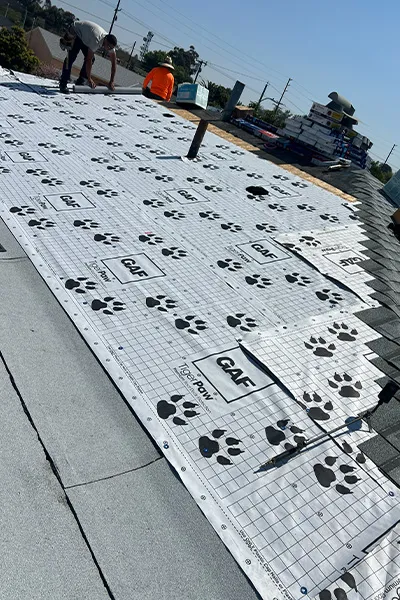 Workers installing synthetic roof underlayment for deck protection to prevent moisture and leaks during roof installation by 3B Roofing in Los Angeles County