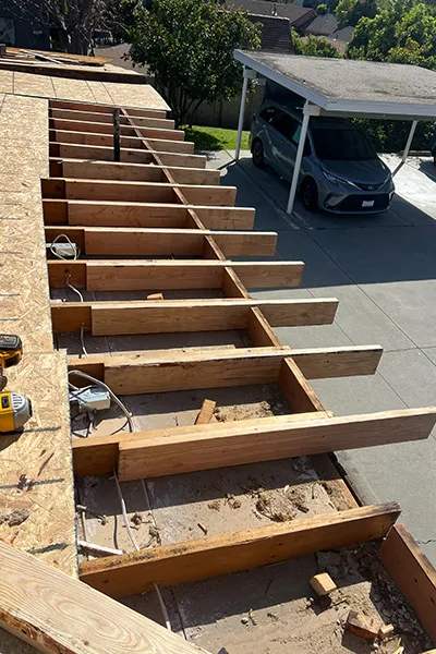 Wood roof framing with joists and cantilever structure during construction with electrical rough in on residential project in Los Angeles County