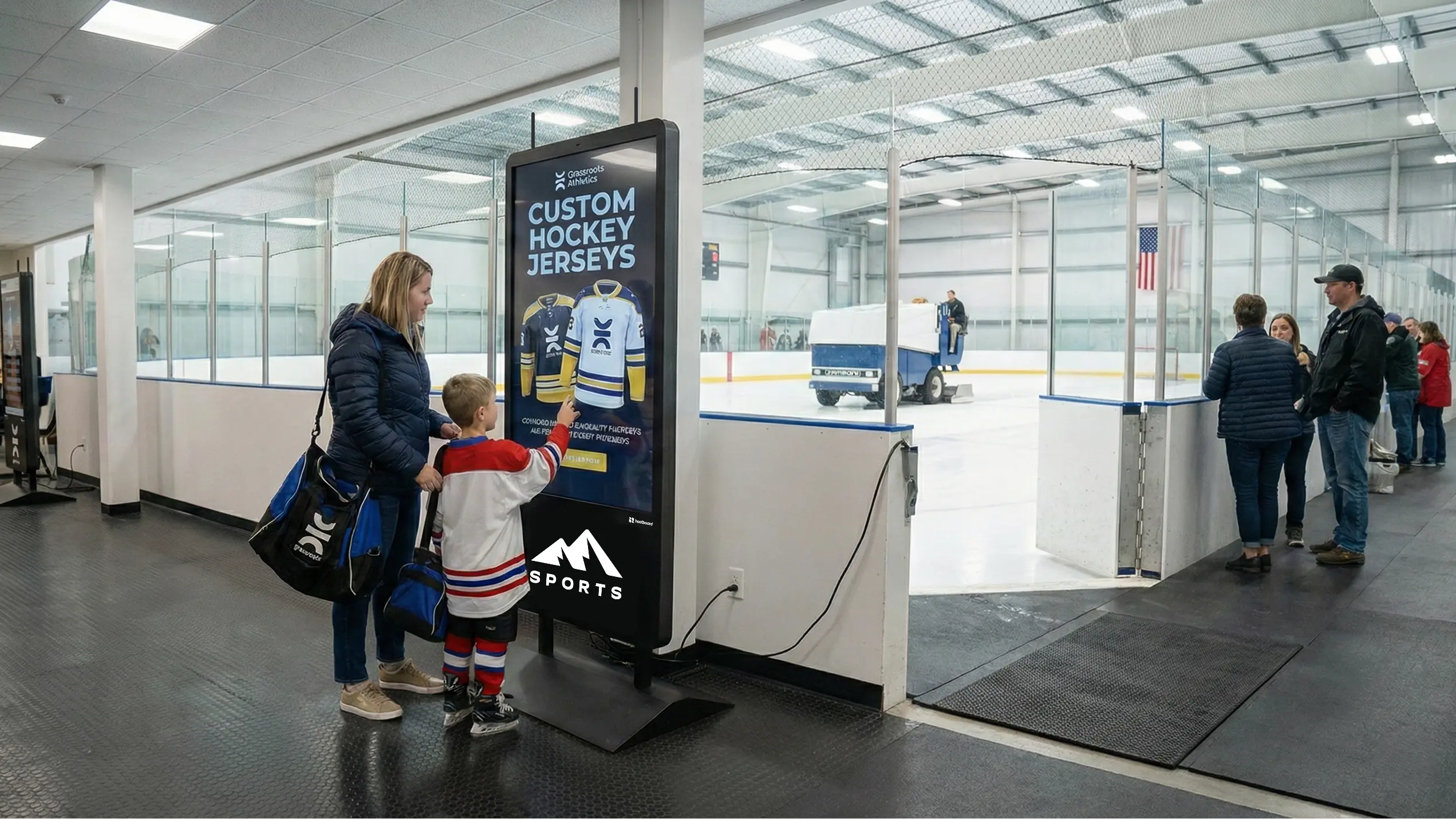 A parent and child interacting with a kiosk at an ice rink