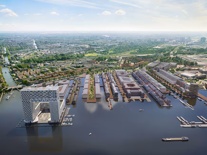 Luchtfoto van Houthaven Amsterdam met water, moderne gebouwen en groene stedelijke gebieden erachter.