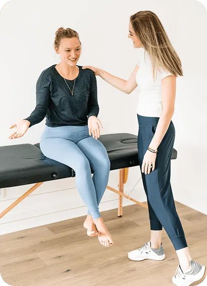 Dr. Lynne DiPirro talking with a woman seated on a treatment table during a pelvic health visit