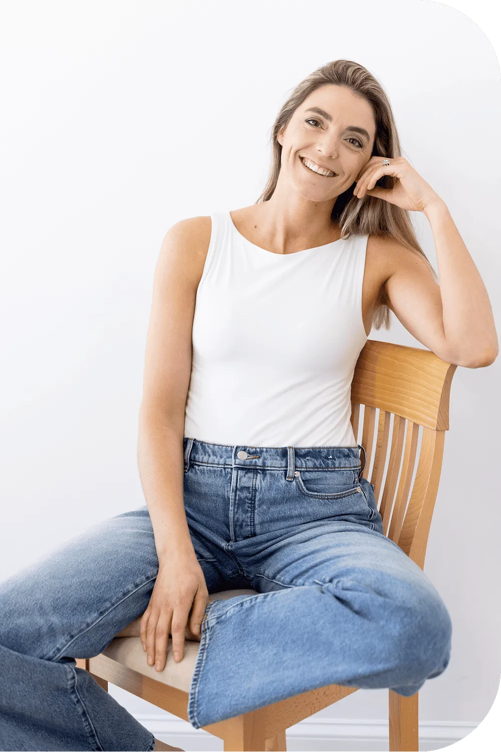 Dr. Lynne DiPirro smiling on a wooden chair, offering private, one-on-one pelvic floor care