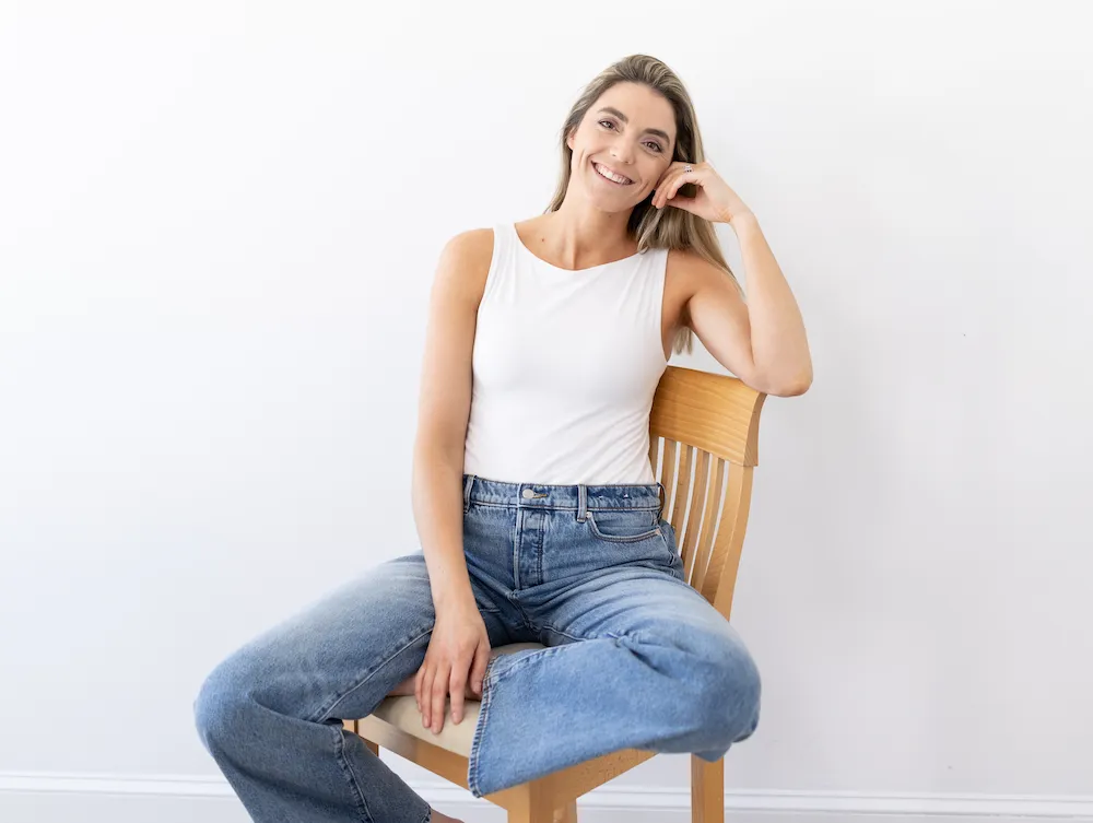 Dr. Lynne DiPirro smiling on a wooden chair, offering private, one-on-one pelvic floor care