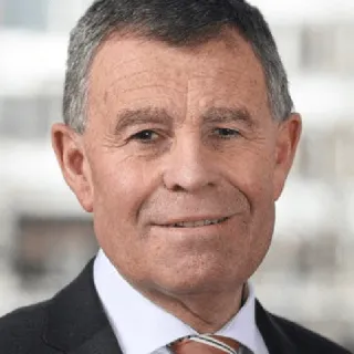 Porträt eines älteren Mannes mit grauen Haaren in schwarzem Anzug und hellem Hemd.