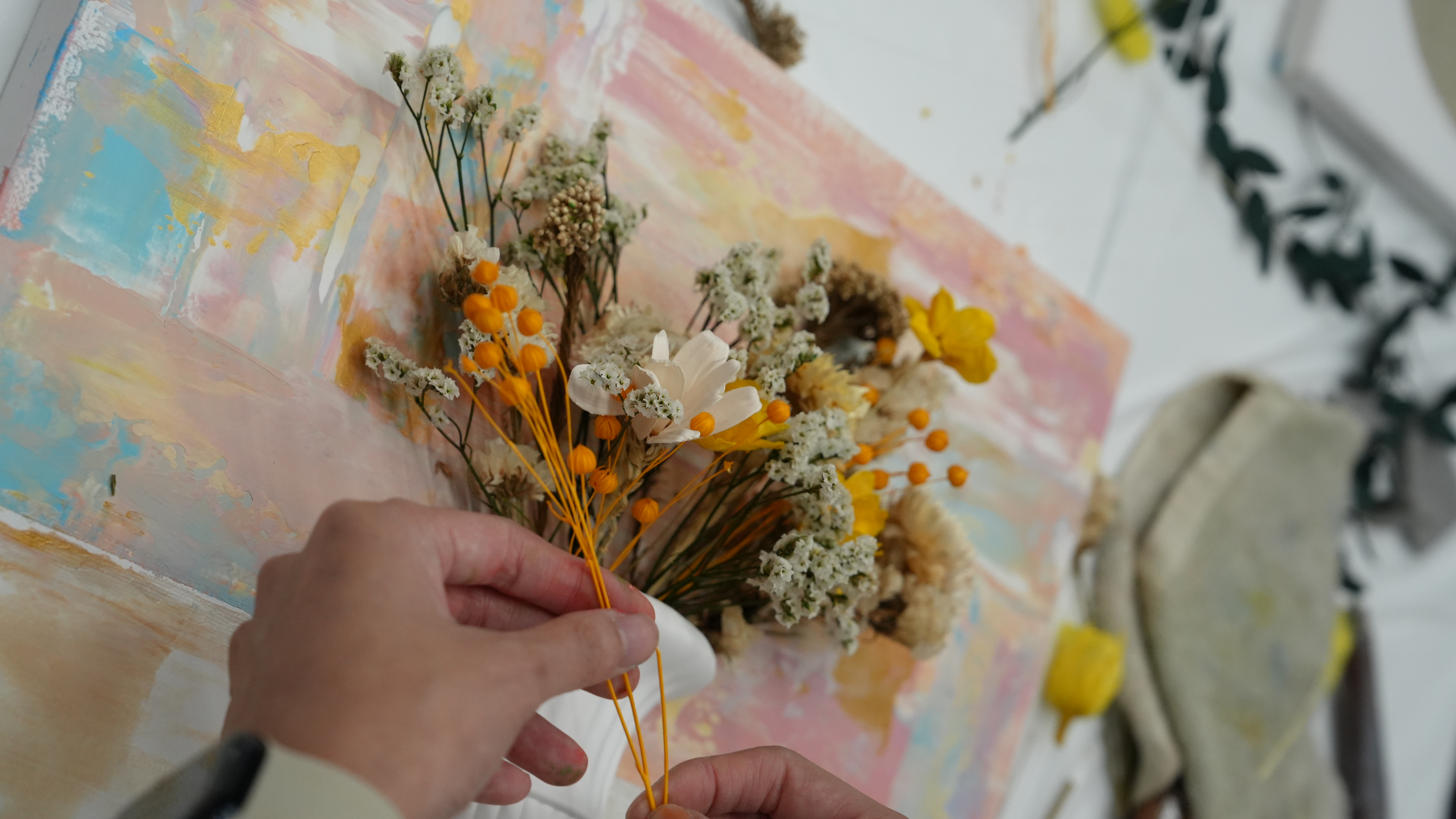 Arranging dried floral elements for textured styled artwork