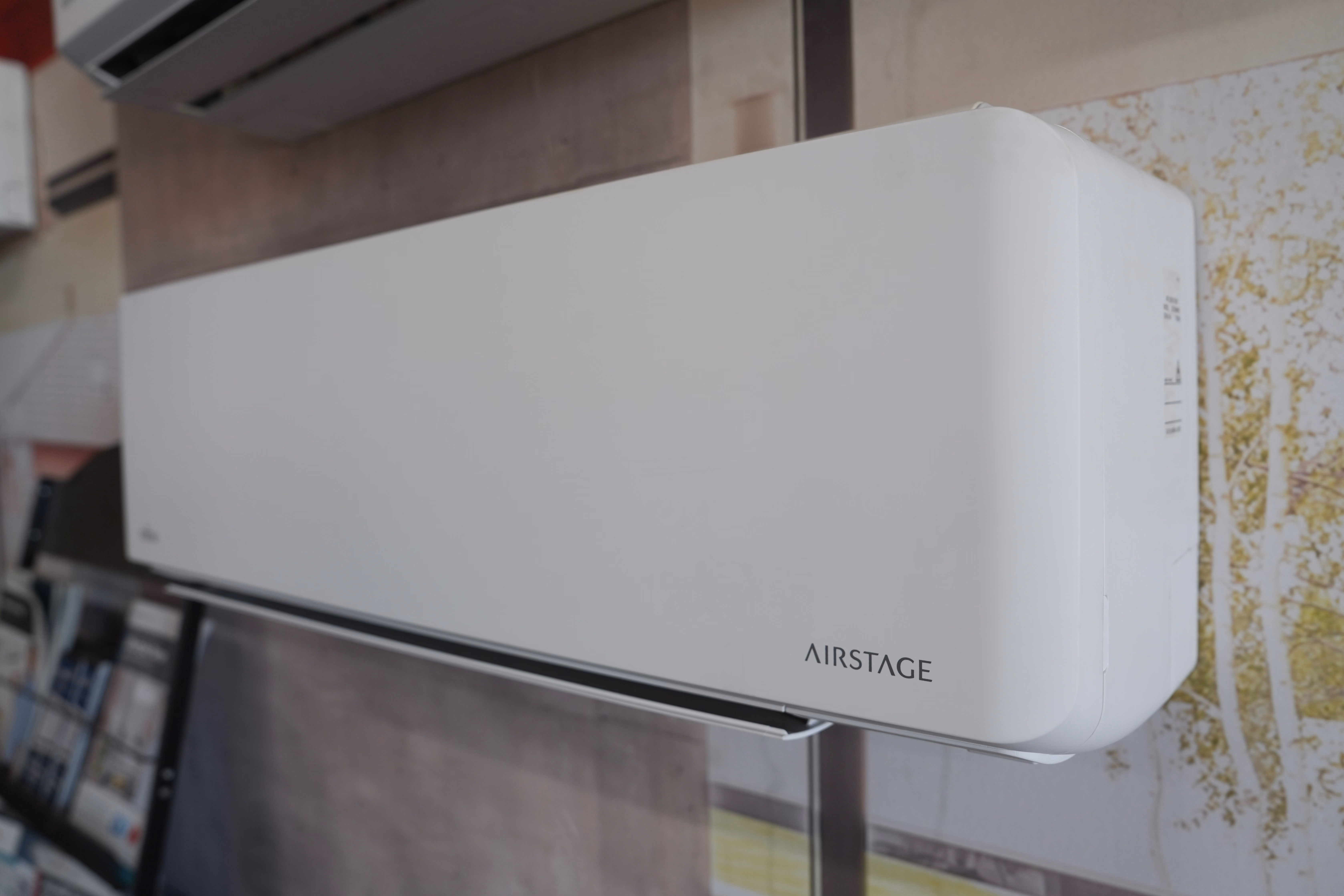 White wall-mounted Airstage air conditioner unit installed indoors.